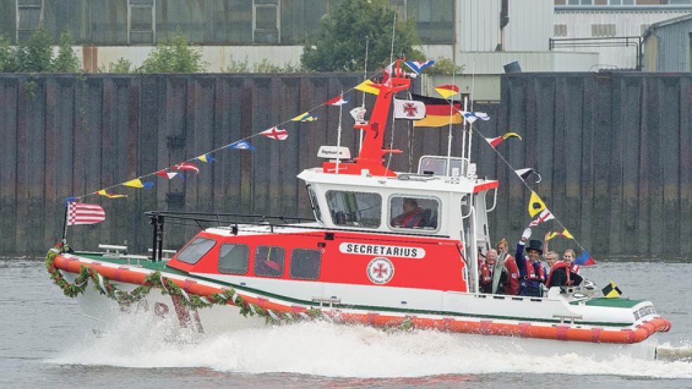 Eiswett-Secretarius Jürgen Albrecht, Eiswettschneider Peter Lüchinger und Taufpatin »Frau Weser« Mareike Bröker grüßen die zahlreichen Freunde und Förderer der Seenotretter an Land.  © Foto: privat