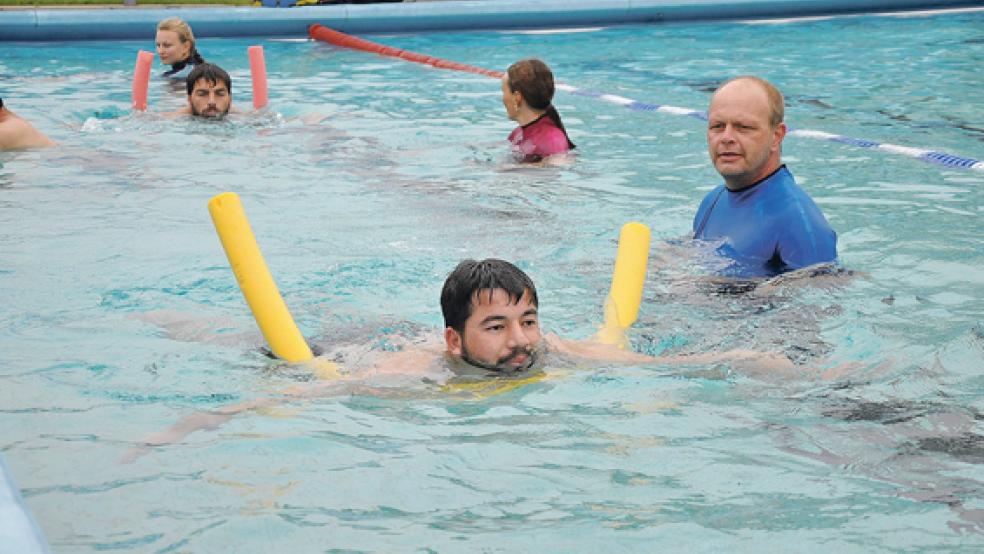 Premiere im Friesenbad: Zum ersten Mal wird ein Männer-Schwimmkurs für Migranten durchgeführt. Mitglieder der Ortsgruppe Weener der Deutschen Lebensrettungsgesellschaft (DLRG) zeigen den Teilnehmern aus Syrien und Eritrea, worauf sie im Wasser zu achten haben.  © Foto: Boelmann