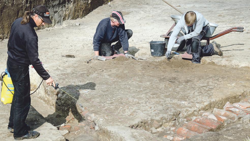 Das Grabungsteam mit Matthias Kastrop, Georg Willms und Praktikant Bastian Einnolf (von links) im Einsatz. Im Vordergrund der freigelegte Weg aus Dachpfannen. © Foto: Hanken