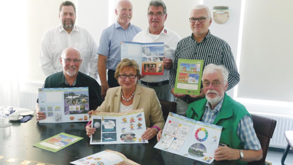 Die Vertreter der Verkehrswachten (stehend von links) Uwe Weber (Aurich), Klaus Wilbers (Wittmund), Diedrich Draeger (Emden), Georg Reichelt (Leer) sowie (unten links) der Gebietsbeauftragte für Ostfriesland Hajo Reershemius (Norden) und (rechts) Wibrandus Reddingius (Leer) mit Brandkassen-­Pressesprecherin Signe Foetzki. © Foto: Jürgens