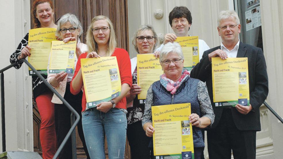 Werben für den Tag des offenen Denkmals in Weener (von links): Organeum-Mitarbeiterin Simone Bleeker, Gästeführerin Birgit Knust, Maren Baumann von der Hafen und Tourismus GmbH (HuT), die städtische Plattdeutschbeauftragte Trinette Hoffbuhr, Else Siemons von den Stapelmoorer Landfrauen, Organeum-Direktor Winfried Dahlke und Bürgermeister Ludwig Sonnenberg auf der Treppe des Organeums in der Norderstraße. © Foto: Szyska