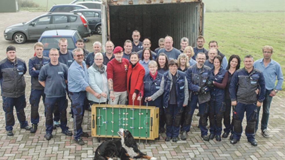 Die Belegschaft der Planenservice Dannen GmbH aus Weener stärkt ihrem Kollegen Nantko Robbes (Mitte mit roter Kappe) bei seinem Hilfsprojekt den Rücken. Die beiden Geschäftsführer Siegfried Dannen (rechts) und Wolfgang Dannen (Fünfter von links) freuen sich über das Engagement der Mitarbeiter und stehen ebenfalls voll dahinter. Unterstützung gibt es auch von der CDU-Bundestagsabgeordneten Gitta Connemann, die auf Vermittlung der CDU-Stadtverbandsvorsitzenden Hildegard Hinderks die Schirmherrschaft übernommen hat. Der Kickertisch, der auf dem Bild zu sehen ist, gehört zu den Hilfsgütern für die Kinder im bis heute unter den Folgen des Bosnienkriegs leidenden Srebrenica. © Foto: Szyska