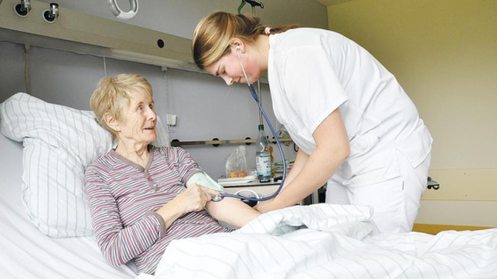 Jenthe ten Hoff, Praktikantin aus den Niederlanden, kümmert sich im Krankenhaus in Weener auch um Patientin Alma Behnke aus Leer. © Foto: Boelmann