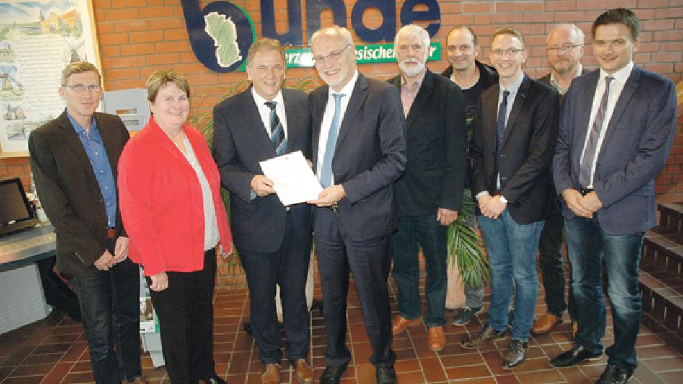 Groß war die Freude gestern im Rathaus in Bunde, als der Landesbeauftragte Franz-Josef Sickelmann den Förderbescheid für das geplante »Familienzen­trum« an Bürgermeister Gerald Sap überreichte. Zusammen mit seinem Allgemeinen Stellvertreter Harm-Markus van Vügt, Bauamtsleiter Manfred de Buhr und Jugendpfleger Werner Hoffmann konnte Sap die SPD-Landtags­abgeordnete Johanne Modder sowie Georg Huisinga und Sven Markus als Mitglieder des Verwaltungsausschusses und Uwe Sap als Vorsitzenden des Jugend- und Sportausschusses zu der offiziellen Übergabe begrüßen. © Foto: Szyska