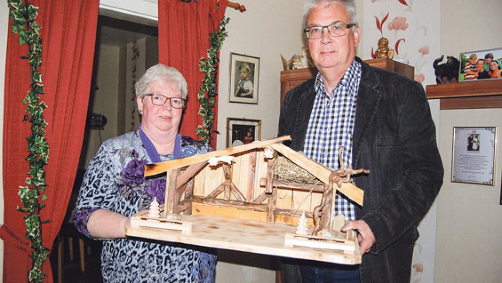 Diese hölzerne Krippe mit 13 handgeschnitzten Figuren wird am Wochenende während der Ausstellung verlost. Anna Fokken und Karlheinz Hinderks präsentieren sie. © Foto: Hoegen