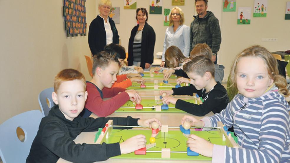 Die Grundschüler probierten gestern Vormittag die vier neuen Tisch-Kicker aus Holz fleißig aus. Darüber freuen sich (von links im Hintergrund) Annegret Schmidt, Anja Meißner, Anja Duitsmann und Bernd Feenders.  © Foto: Boelmann