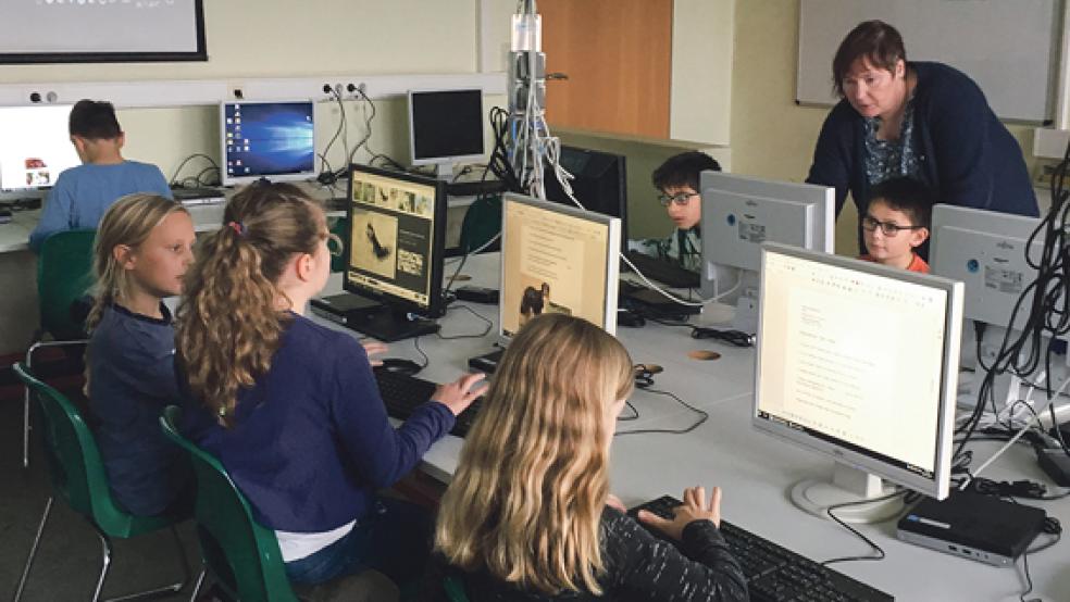 Bärbel Tönsing (hinten rechts) unterstützt die Dritt- und Viertklässler der Grundschule Weener bei der Arbeit am PC. © Foto: Hoegen