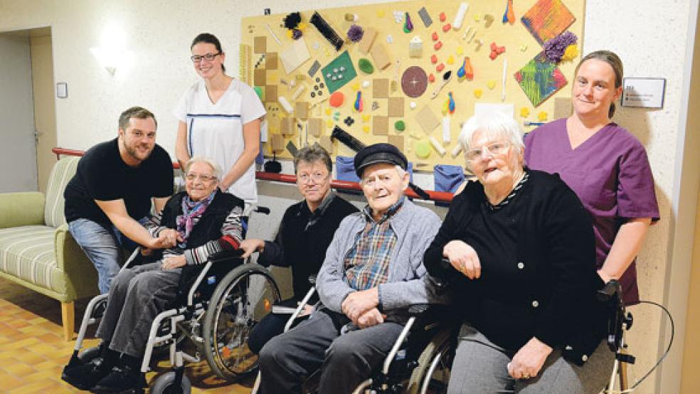 Einige Pflegekräfte des Demenzbereiches, Geschäftsführer Andreas Cramer (Mitte) und die Bewohner sahen sich am Mittwoch die frisch aufgehängten Sinneswände an. © Fotos: ;Muising