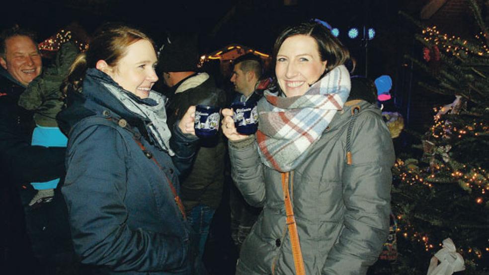 In Ditzum haben die Glühweinbecher keinen Druckfehler wie in Leer, ulkten Jantje Woortmann (links) und Yvonne Penning. Der Markt im Fischerdorf an der Ems war bereits am Mittag gut besucht. © Fotos: Kuper