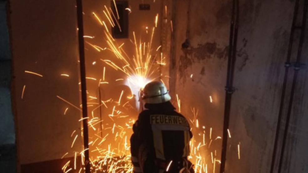 Mit einem Trennschleifer schnitt die Feuerwehr ein Loch in die Fahrstuhltür. © Foto: Feuerwehr