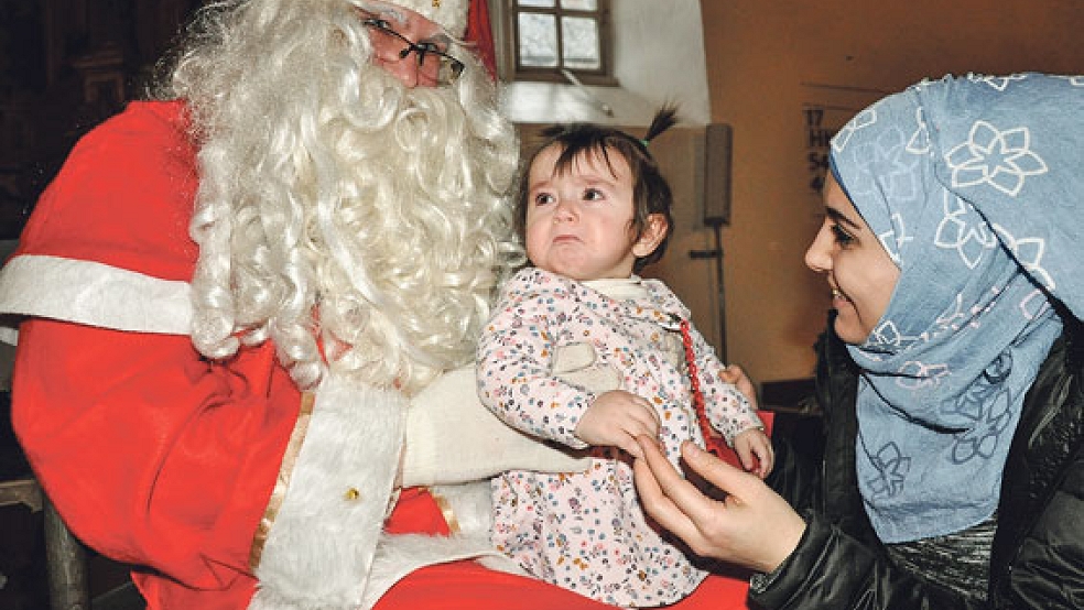 An ihrem Geburtstag hat die kleine Mira mit ihrer Mama Samara den Weihnachtsmann zum ersten Mal in der Georgskirche getroffen. Es kullerten auch ein paar Tränen.  © Fotos: Boelmann