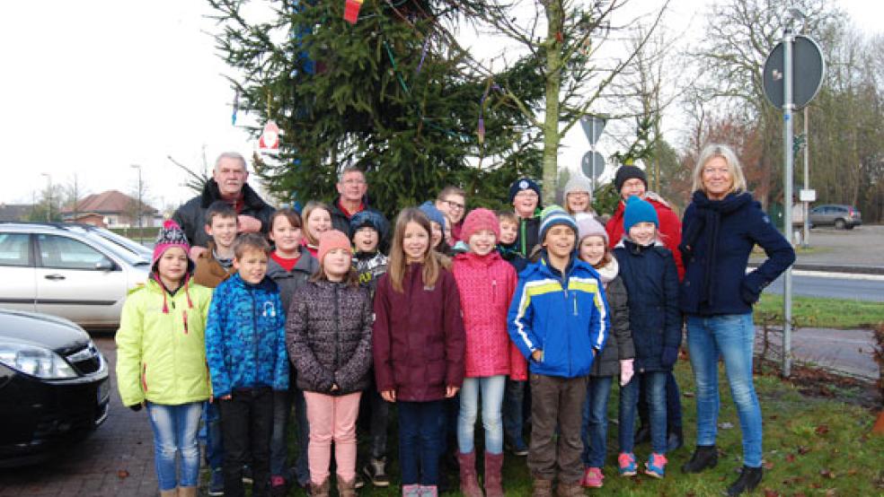 Vor dem Weihnachtsmarkt des Dorfvereins in Möhlenwarf sorgt die Grundschule schon traditonell dafür, dass der Weihnachtsbaum vor dem NP-Markt geschmückt wird. © Foto: Archiv