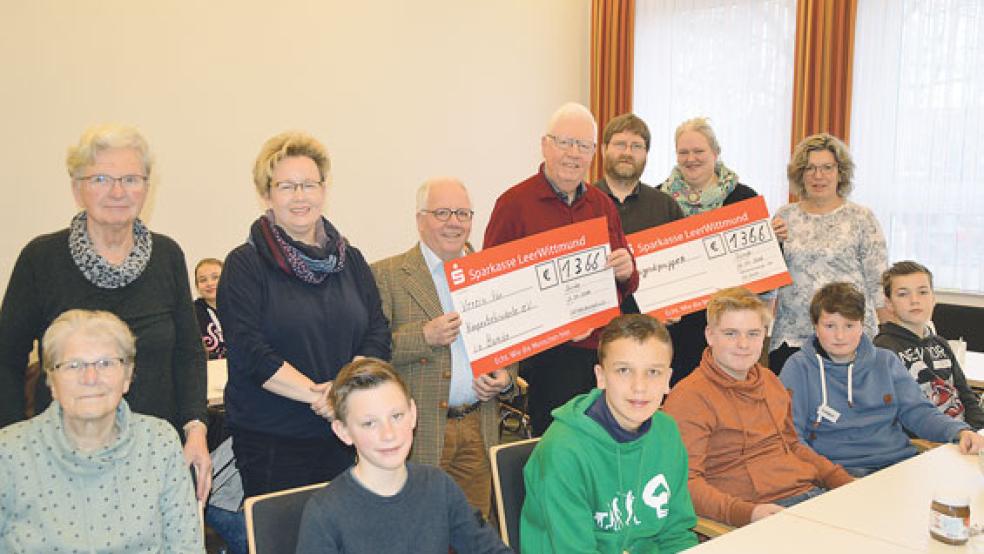 Das Foto zeigt bei der Scheckübergabe einige Konfirmanden sowie Gerda Hahn (von links), Edith Huisinga, und Elke Klinkenborg vom Aktionsausschuss, Hinrich Winterboer und Jan-Dieter van Hoorn vom Verein für Körperbehinderte sowie Pastor Ard Nap, Antje Meinders und Gertrud Vry, ebenfalls vom Aktionsausschuss.  © Foto: Himstedt