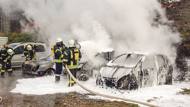 Drei Autos stehen in Flammen