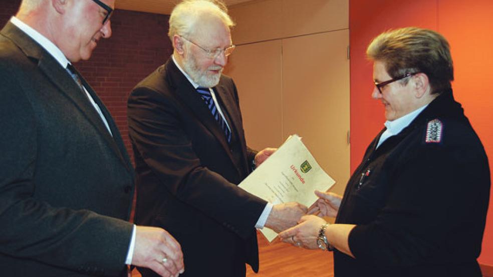 Antje Lüdemann nahm für die Jugendfeuerwehr Jemgum, die einen der beiden ersten Plätze belegte, den Umweltpreis der Gemeinde Jemgum entgegen. Arnold Venema überreicht die Urkunde, Bürgermeister Hans-Peter Heikens will gerade gratulieren. © Foto: Hoegen