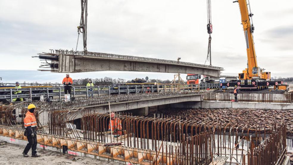 Rund 35 Tonnen Beton am Haken: Zwei Schwerlastkräne der Neermoorer Firma Ulferts bugsieren die 20 Meter langen Brückenteile an ihre Position. Am Wochenende wiederholte sich diese Aktion 14 Mal. © Foto: Hasseler