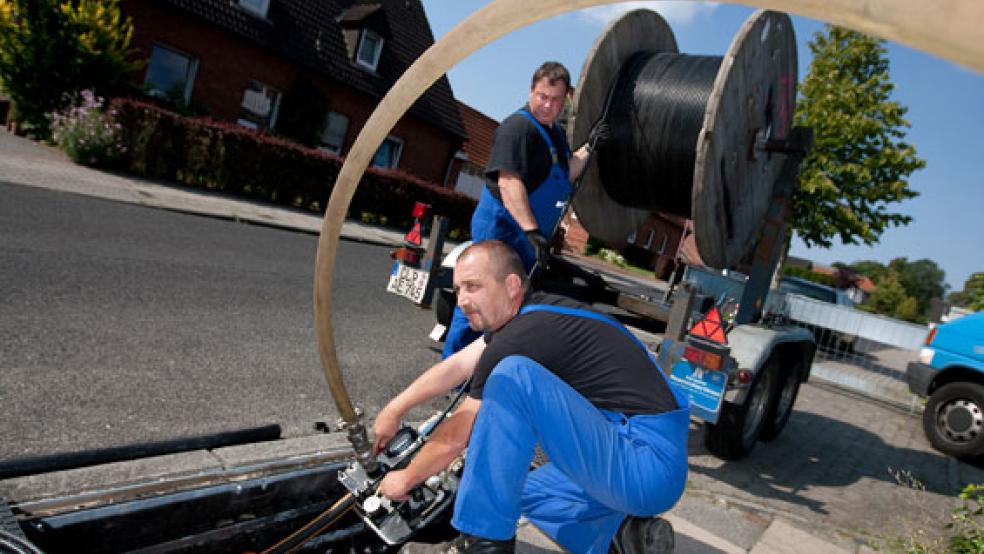 Glasfaser werden von EWE-Mitarbeitern in ein Kabel eingeblasen. Der Landkreis Leer setzt auch weiterhin auf diese Versorgungstechnik beim Breitband-Ausbau - kann aber noch nicht alle Adressen damit erreichen. © Foto: EWE