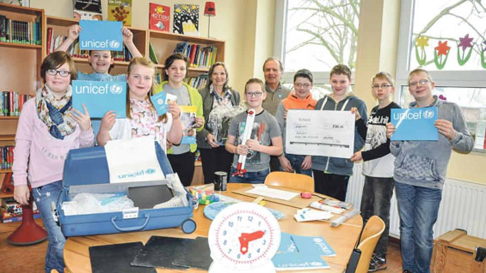 Schüler der Klasse 6 der Pestalozzischule in Weener haben sich im Unterricht mit dem Thema »Kinderrechte« beschäftigt und kräftig Spenden für Kinder in Afrika gesammelt. Eine Spende in Höhe von 500 Euro überreichte Heidrun Pals von der Firma »Allpax« aus Papenburg (Fünfte von links). Darüber freute sich auch Gerd Bartinger von der Unicef-Arbeitsgruppe Ostfriesland (Fünfter von rechts).  © Foto: Boelmann