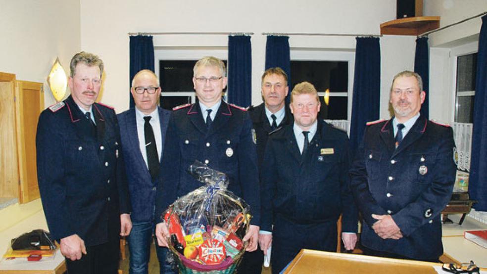 Präsentkorb, Urkunde und Anstecknadel erhielt Albert Freesemann für seine 25-jährige Mitgliedschaft in der Freiwilligen Feuerwehr. Mit auf dem Foto (von links) Gerold Foget, der als Stellvertreter des Ortsbrandmeisters wiedergewählt wurde, Bürgermeister Hans-Peter Heikens, Gemeindebrandmeister Jan Hilbrands, stellvertretender Brandschutzabschnittsleiter Süd Holger Bleicher und Ortsbrandmeister Wilhelm Pruin. © Fotos: Kuper