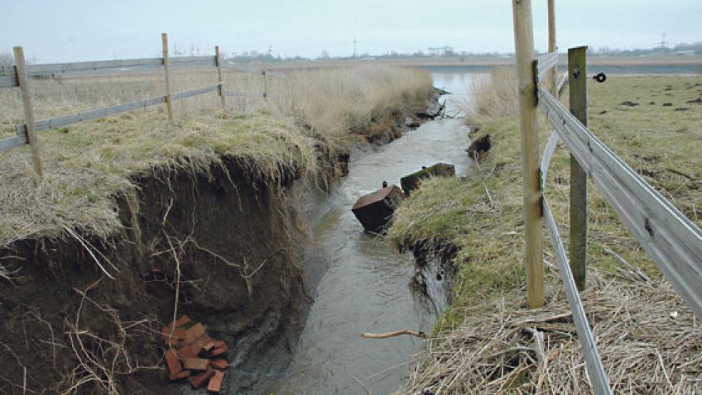 Der Sommerdeich zwischen der Ems und dem Baggersee der »Ems Marina« in Bingum ist auf einer Breite von zwei bis drei Metern durchbrochen. Die dortige Schleuse wurde komplett zerstört, die Trümmerteile liegen im Wasser. © Foto: Szyska