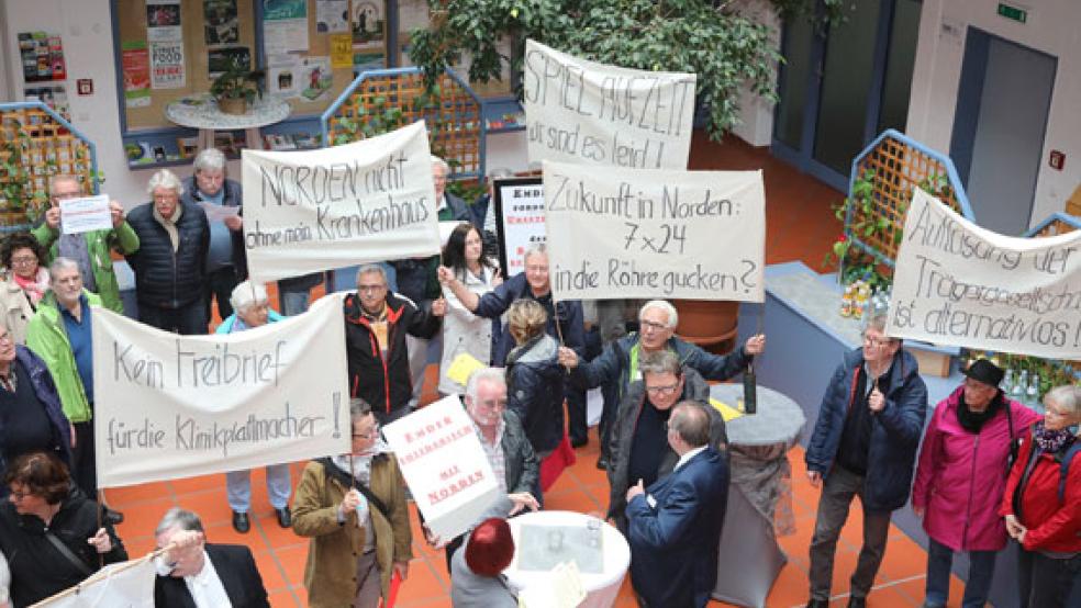 Vor der gemeinsamen Sitzung von Kreistag und Emder Stadtrat demonstrierten Aktivisten des Norder UEK-Fördervereins und des Aktionsbündnisses für den Erhalt wohnortnaher Krankenhäuser im Foyer der Auricher Kreisvolkshochschule. © Foto: Banik