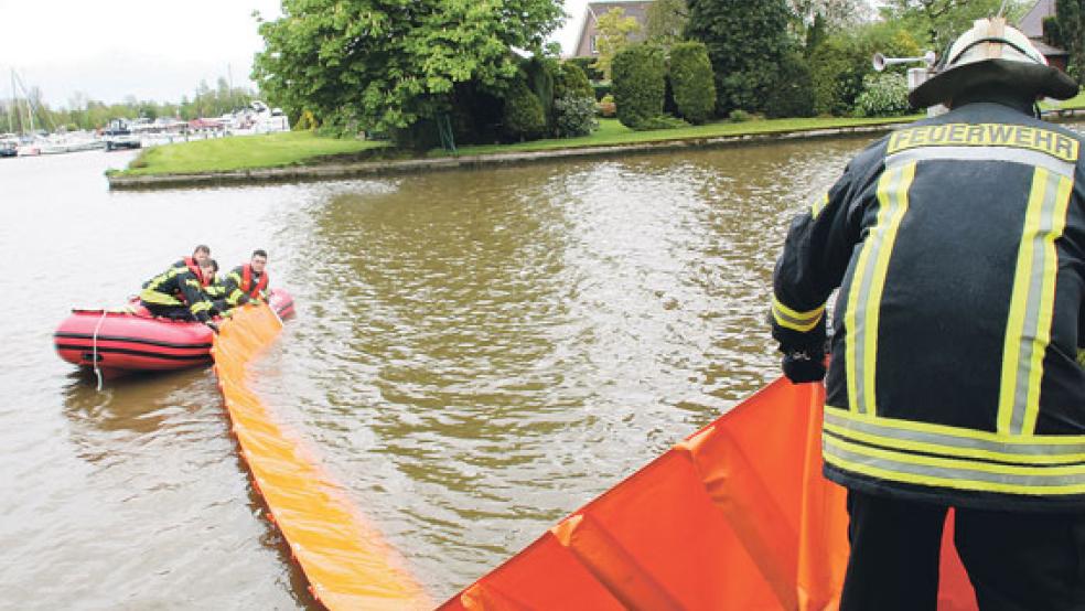 Mit Hilfe eines Bootes brachten die Feuerwehrleute die Ölsperren im Alten Hafen aus. © Foto:J. Rand (Feuerwehr)