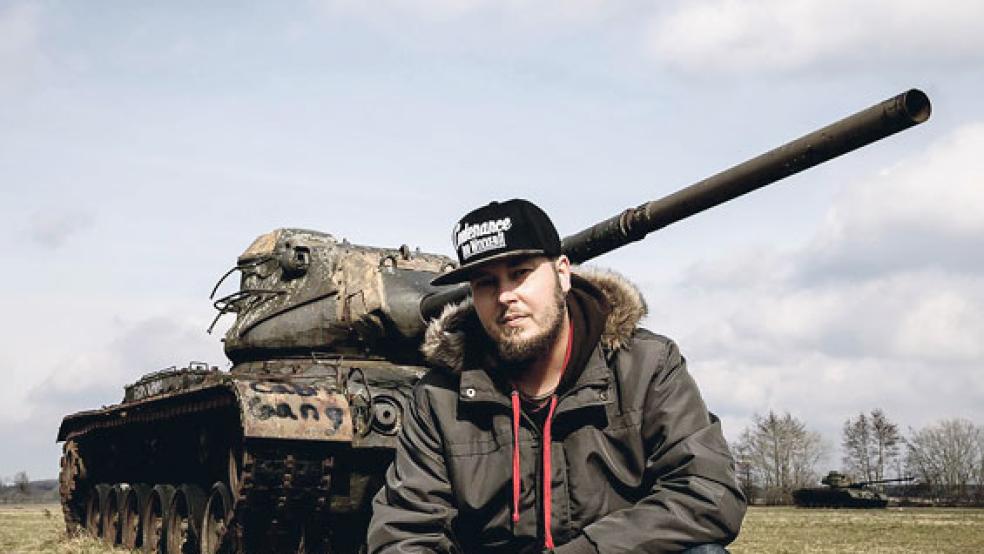 Dennis Hilk vor einem ausrangierten Panzer auf einem Übungsplatz im Hümmling. Hier befand sich früher das Dorf Wahn, das 1941 auf Anordnung von Adolf Hitler einer Erweiterung des Schießplatzes weichen musste. . © Foto: privat