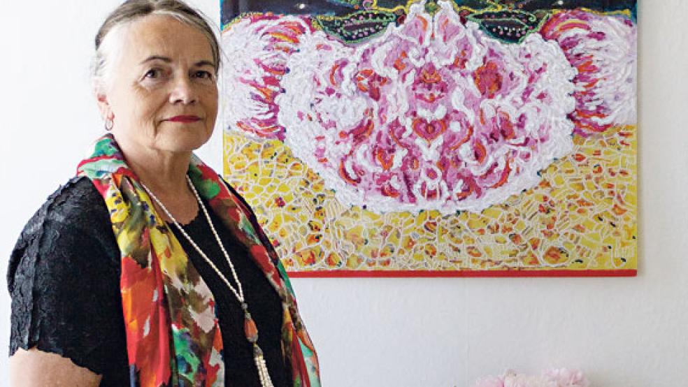 Wilma Mencke präsentiert ihre Lieblingsblume, welche sie in einem »Hinterglasbild« verewigt hat.  © Fotos: Ostendorp