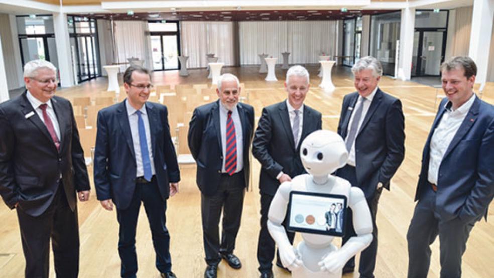 Westworld lässt grüßen: Bei der Vorstellung der ersten Digitalen Woche unterhalten sich die Partner der Veranstaltung mit dem humanoiden Roboter »Pepper« vom Modehaus Leffers: Von links: Frank Fastenau (Sparkasse), Thomas Dreesmann, Harald Krebs und Landrat Matthias Groote (alle Landkreis Leer), Sparkassenvorstand Heinz Feldmann und Orgadata-Chef Bernd Hillbrands. © Foto: Landkreis Leer