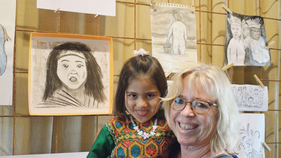 Original und Kopie… stolz posiert die kleine Nazanin mit Catharina Bockhacker vor ihrem Porträt. Sandra und Dietmar Vogt aus Leer präsentieren einen »Demon-Protection-Bat« (kleines Bild, unten) und Charly (links) und Stanley machten spontan Musik.  © Fotos: Himstedt