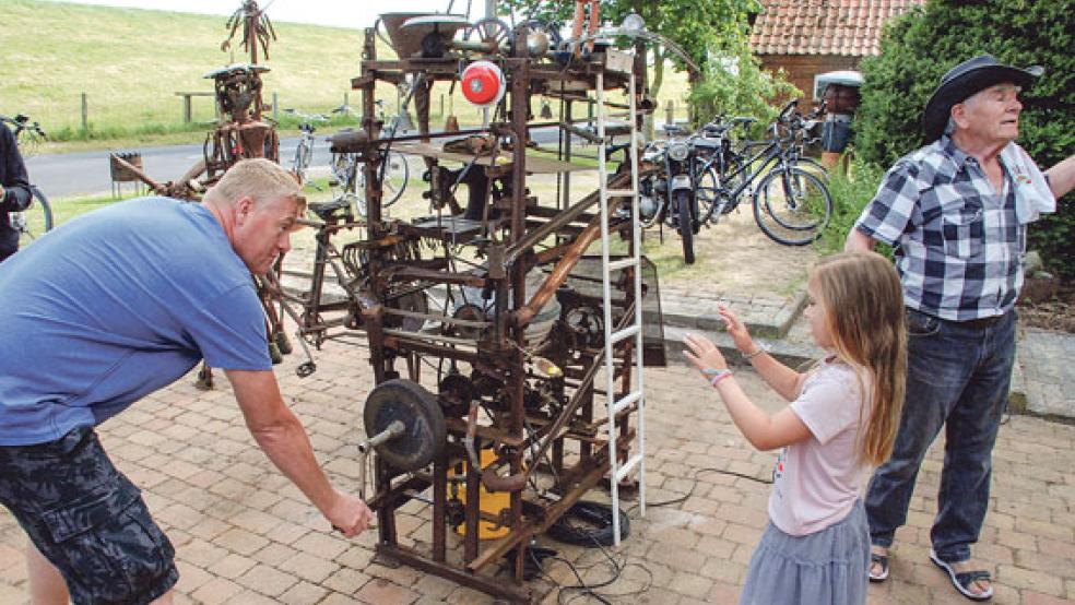 Schrottkunst und Kinderspaß: Der Spanier Amador Cicuendez (rechts im Bild) konstruierte aus Schrott eine wundersame Maschine, die Bonbons in die Luft schleudert. © Fotos: Kuper