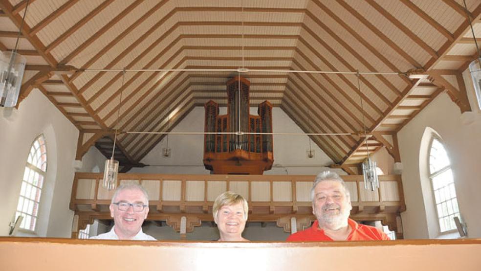 Freuen sich auf viele Besucher beim Festgottesdienst am 12. August in der ev.-ref. Kirche in Möhlenwarf (von links):Joachim Tjabben (Vorsitzender des Kirchenrats), Anne Ulferts (Pastorin) und Heinz-Gerd Reinberg (Organist). Anlass ist der 50. Geburtstag der Reil-Orgel.  © Foto: Boelmann