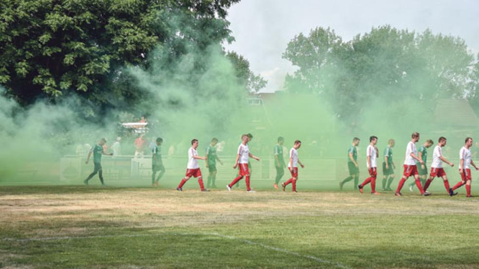 Die beiden Mannschaften schälten sich nach und nach aus dem dichten grünen Rauch und marschierten in Richtung Mittelkreis. © Fotos: Hilbrands