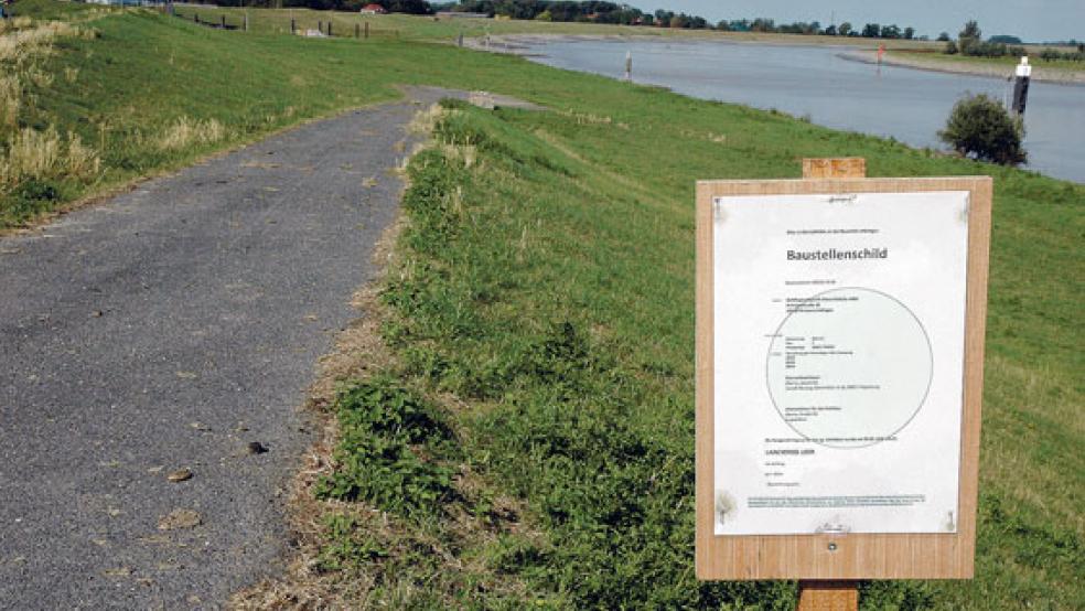 Die Deichrampe führt als geteerter Weg zu einem Platz im Deichvorland, auf dem früher stets das Weeneraner Osterfeuer gefeiert wurde. Von dort bis zum Fähranleger sind es gut 200 Meter, auf denen noch ein Weg angelegt werden muss. Das ist nach Angaben des Landkreises Leer seit Mai 2017 bekannt, doch bisher weist nur ein Baustellenschild darauf hin. © Foto: Szyska