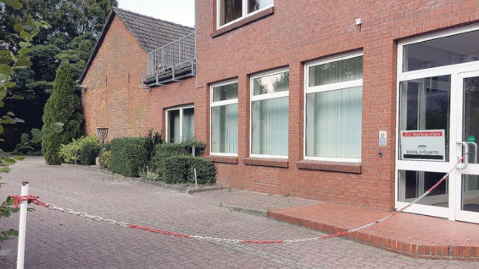 Der abgesperrte Parkplatz mit der Menora im Hintergrund. Ein Schild im Fenster des Gebäudes weist auf den Verkauf hin. © Foto: Hanken