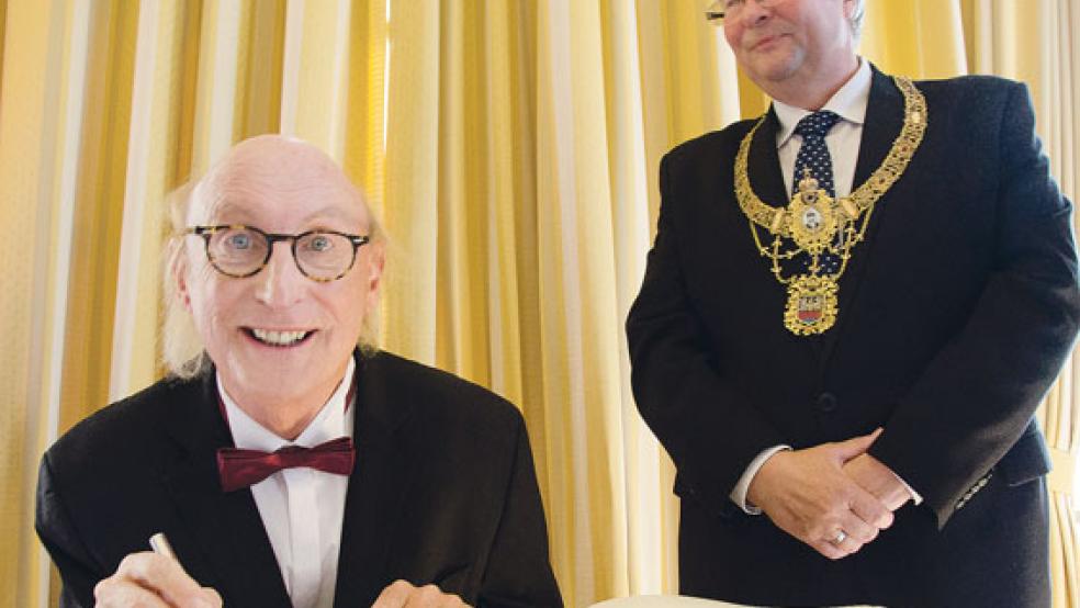 Stolz wie Oskar - oder eben Otto. Kultkomiker Waalkes trug sich im Beisein von Oberbürgermeister Bernd Bornemann in das Goldene Buch der Stadt Emden ein. © Foto: Hanken
