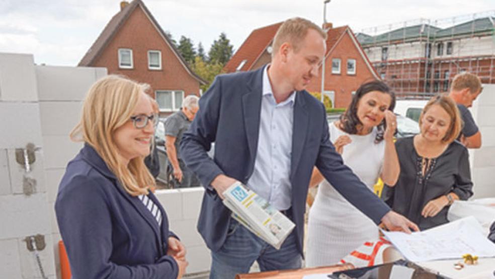 Geschäftsführer Andreas Aikens packt eine aktuelle RZ-Ausgabe in die Zeitkapsel. Der Möhlenwarfer ist zusammen mit Mareike Glander (links) Geschäftsführer der Krippen-Gesellschaft in Moormerland. Rechts: Bürgermeisterin Bettina Stöhr und die CDU-Bundestagsabgeordnete Gitta Connemann, die Ehrengäste der Grundsteinlegung waren.  © Fotos: privat