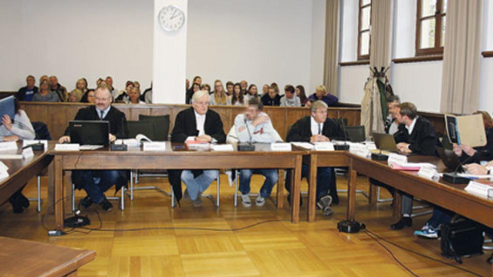 Zahlreiche Zuschauer verfolgten den Auftakt des Mordprozesses. Die beiden weiblichen Angeklagten (links und Dritte von rechts) schützten mit Aktendeckeln ihre Gesichter vor den Kameras, der Mitangeklagte (Vierter von links) verzichtete darauf. © Foto: Ricken