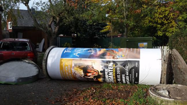 Litfasssäule kippt um und stößt gegen Auto