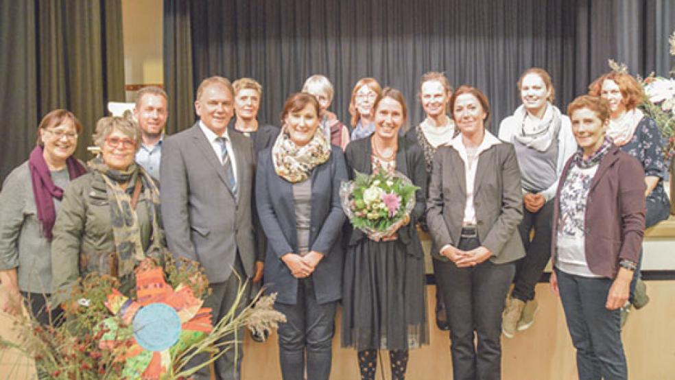 Mit offenen Armen und vielen herzlichen Worten wurde Ann-Charlott Meinen (Mitte rechts) offiziell als Leiterin der Grundschule Bunde eingesetzt. Zu den ersten Gratulanten gehörten das Kollegium, die kommissarischen Vorgängerinnen Andrea Schepers (Mitte links) und Hermine Kramer (rechts) sowie Bürgermeister Gerald Sap und die Dezernentin der Landesschulbehörde Aurich Evelyn de Vries (vorne, Zweite von rechts). . © Foto: Himstedt