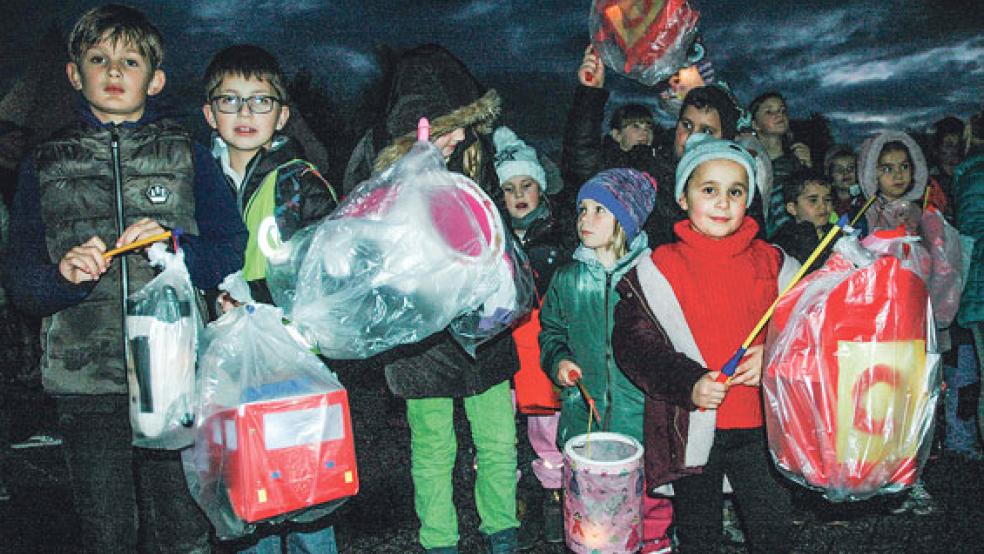 Die Kinder schützten ihre selbstgebastelten Laternen gestern in Weener mit Plastiktüten vor dem Regen. © Foto: Szyska