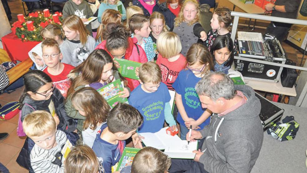 Marco Bode, Ex-Profifußballer von Werder Bremen, hat nicht nur zwei Geschichten vorgelesen, sondern auch viele Autogramme geschrieben. Zuvor hatten die Grundschüler ein vielfältiges Programm in der Pausenhalle auf die Beine gestellt.  © Fotos: Boelmann