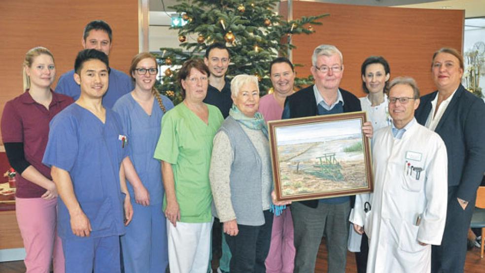 Mit einem Gemälde vom Dollart bedankte sich Monne de Vries bei der Mediclin-Hedon Klinik Lingen für die erfolgreiche Behandlung seiner seltenen Rückenmarkserkrankung (von rechts): die Pflegedirektorin Ute Schlauer-Doeinck, der Chefarzt der Fachklinik für Neurologische Rehabilitation Dr. Michael Annas, die leitende Oberärztin Dr. Lioba Rückriem, Monne de Vries, Ingrid Mielke als stellvertretende Pflegedienstleitung, Gretchen de Vries und das neurologische Reha-Team mit Therapeuten der Ergotherapie und der Krankengymnastik sowie den Kranken- und Gesundheitspflegerinnen. © Foto: Reis