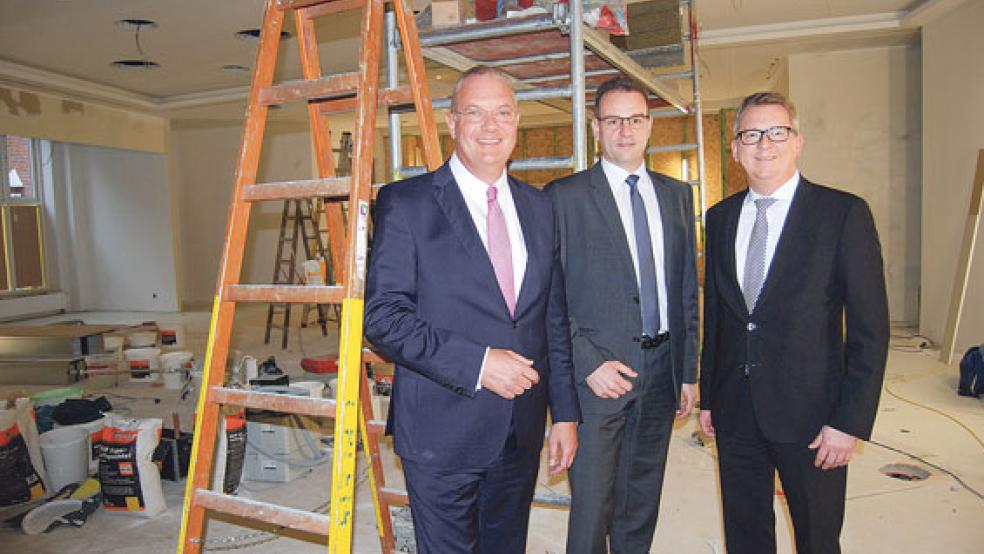 Auf der Baustelle: Der Vorstand, bestehend aus Holger Franz (links), Georg Alder und Joachim Fecht (rechts), zeigte gestern auch das derzeitige Bild, dass die Kassenhalle der Hauptstelle an der Mühlenstraße bietet. Bis zum März, wenn die Genossenschaftsbank ihr 150-jähriges Jubiläum feiert, soll die Neugestaltung der Hauptstelle abgeschlossen sein. © Foto: Hoegen