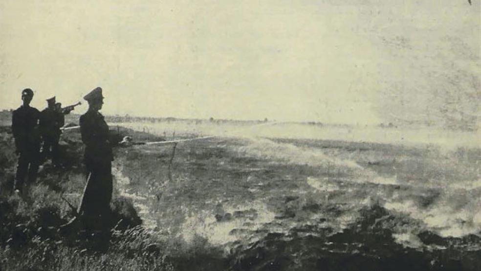 Mehrere Feuerwehrmänner stehen im Jahr 1959 am Rande eines großen Moorfeldes in Wymeer und löschen den Brandherd. Vom Feuer ist eine Fläche von zwei Quadratkilometern betroffen. © RZ-Archiv: G. Risius