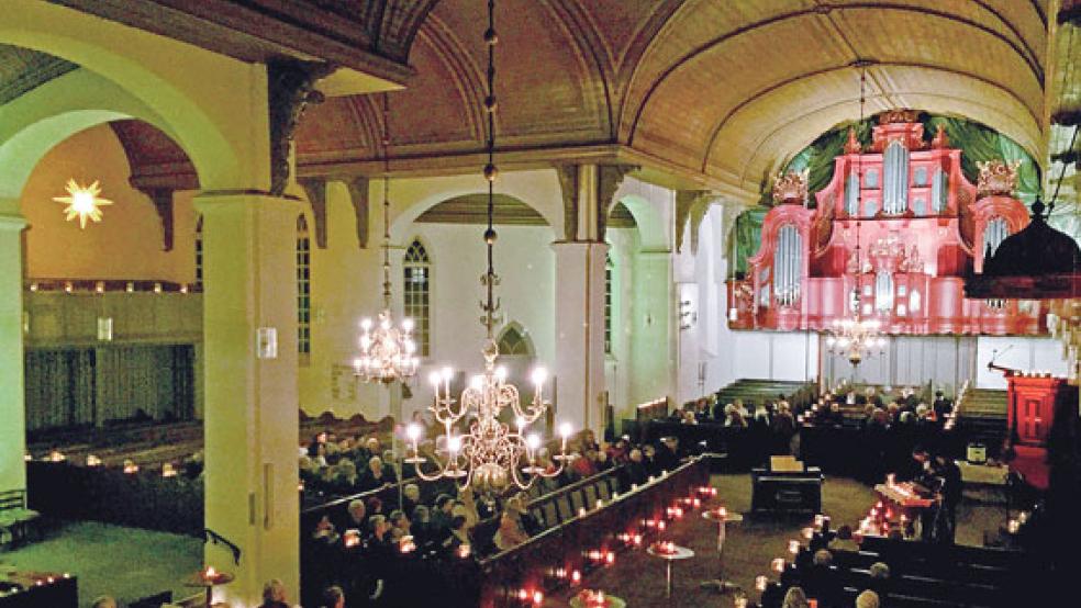 Mit vielen flackernden Kerzen und dezent-farbiger Beleuchtung präsentierte sich die Georgskirche in Weener. © Foto: Kuper