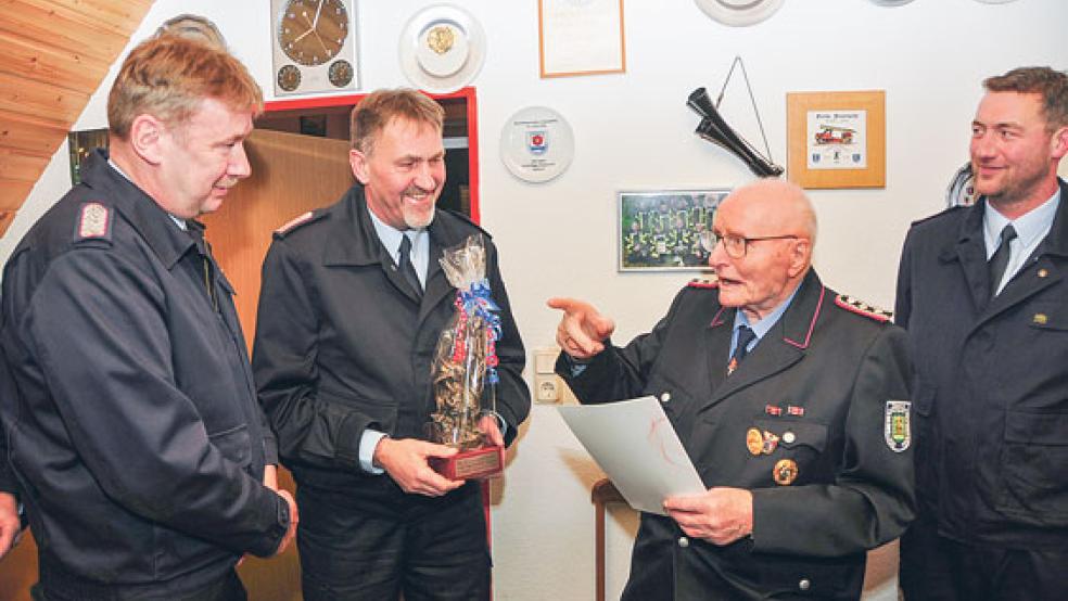 Abschnittsleiter Ernst Berends und Gemeindebrandmeister Jan Hilbrands ehrten Freerk von Lessen für seine 70-jährige Mitgliedschaft (von links). Rechts im Bild der stellvertretende Ortsbrandmeister Enno Rösingh. © Fotos: Wolters