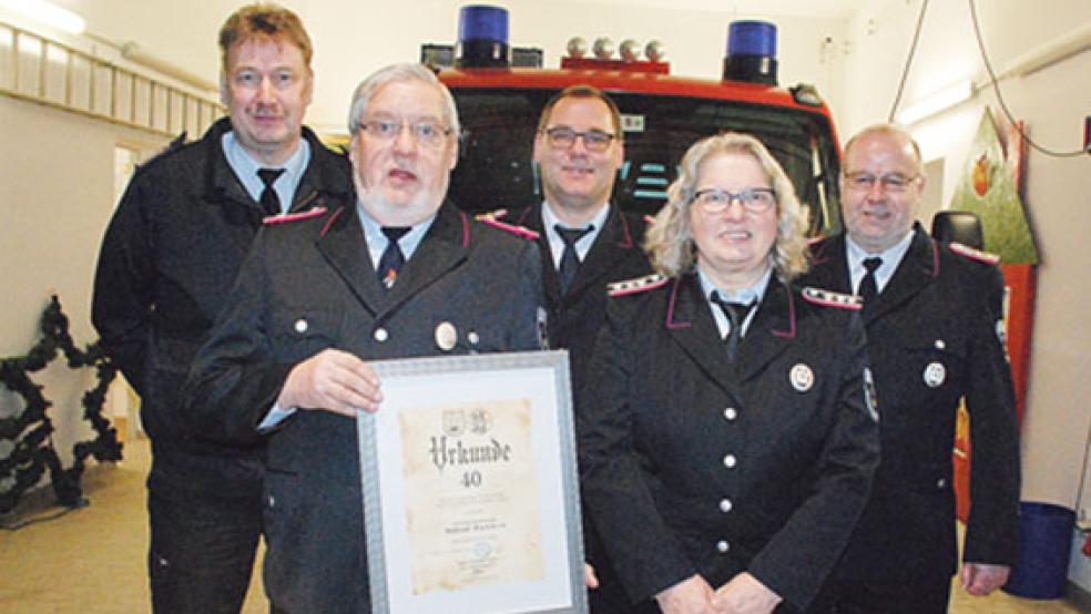 Ehrung und Abschied für zwei verdiente Mitglieder der Feuerwehr Vellage: Wilfried Hanken (mit Urkunde) wurde für 40 Jahre Mitgliedschaft in der Feuerwehr geehrt, Elfriede Spekker in die Altersabteilung verabschiedet. Mit auf dem Foto sind (von links) Abschnittsleiter Ernst Berend (Kreisfeuerwehr) sowie Stadtbrandmeister Jörg Fisser und sein Stellvertreter Gerhard Kuper. © Fotos: Kuper