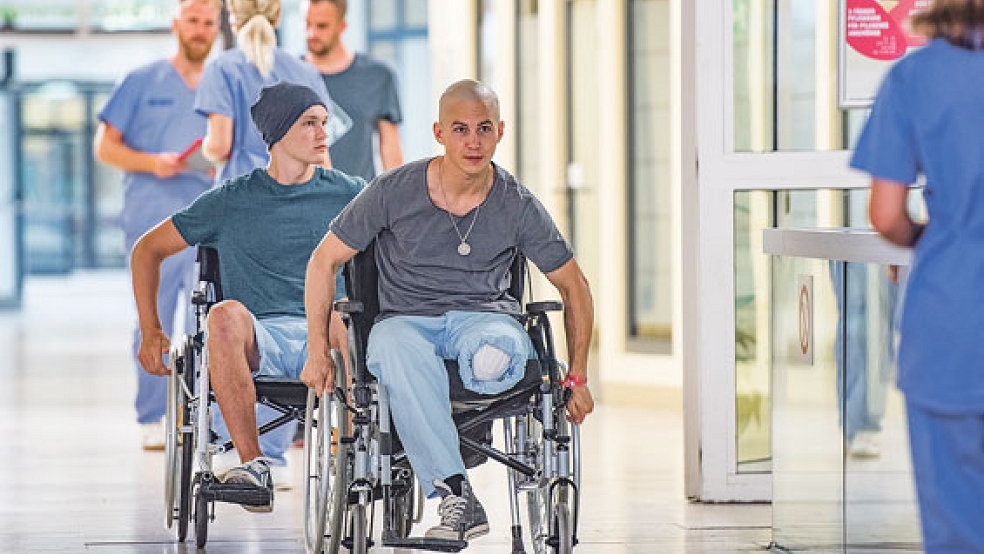 Lebenswille: Leo (Tim Oliver Schulz, rechts) und Jonas (Damian Hardung) liefern sich ein Rollstuhl-Wettrennen auf dem Krankenhaus-Flur.  © Foto: Universum Film