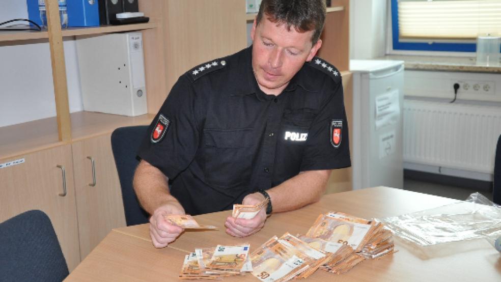 Bargeld in Höhe von rund 10.000 Euro lag nach einer Automatensprengung in Weener auf der Straße. Jetzt wurden zwei mutmaßliche Täter gefasst. Ralf Hickmann, heute leitet er die Polizeistation in Weener, war damals mit dem Zählen des gefundenen Bargeldes beschäftigt. © Foto: Boelmann